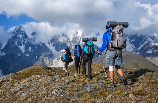 Group of tourists with large backpacks are on mountain