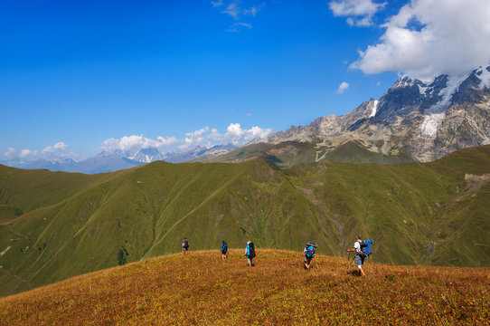 Group of tourists with large backpacks are on mountain
