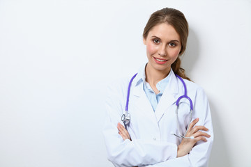 Fototapeta premium Friendly smiling young female doctor, standing near wall