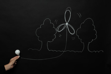 Mano che disegna su lavagna e mostra una lampadina