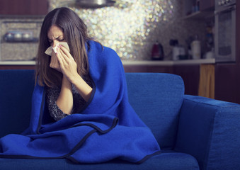Sick young woman is coughing and blowing