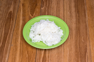 rice vermicelli in green dish on wooden board