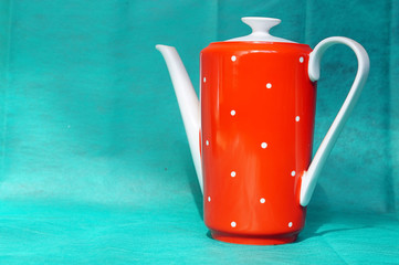 Red teapot with a spout and a handle white