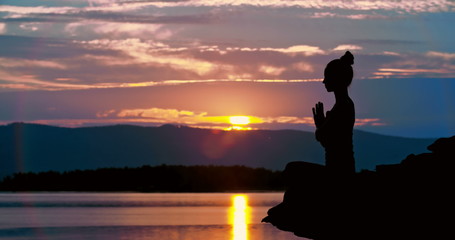 Side view of woman practicing meditation in nature at dusk  - Powered by Adobe
