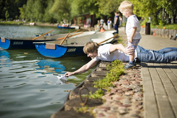 Father and son starting paper boat