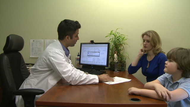 Male doctor consults with mother and son