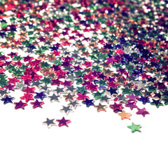 Scattered glittering stars confetti. Close up. Star background with copy space. Toned  photo. Text frame with plenty of colorful stars.