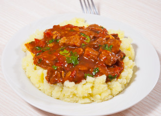 meat in sauce with mashed potatoes