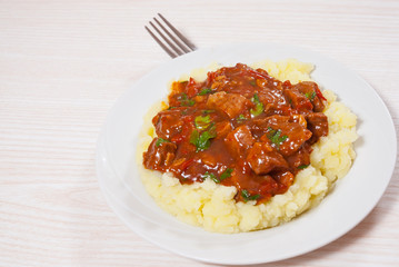 meat in sauce with mashed potatoes