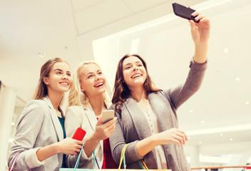 women with smartphones shopping and taking selfie