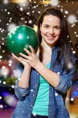 Fototapeta premium happy young woman holding ball in bowling club