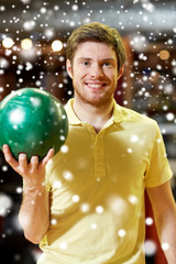 Fototapeta premium happy young man holding ball in bowling club