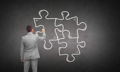 businessman drawing puzzle