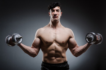 Muscular ripped bodybuilder with dumbbells