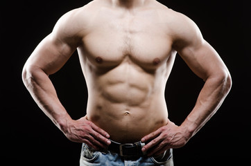 Fototapeta premium Muscular man posing in dark studio