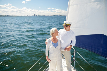 Fototapeta premium senior couple hugging on sail boat or yacht in sea