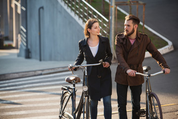 Young couple with on a bicycle opposite city 