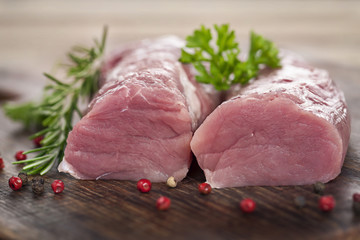 Rohes Schweinefilet auf edlem Holzbrett