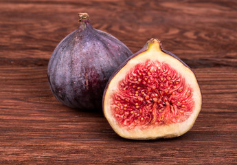 Half sliced fresh figs with fruit on a wooden background