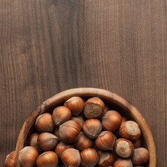 hazelnuts in wooden bowl on the brown table