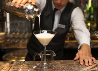 Crédence de cuisine en verre imprimé Cocktail Barman at work, preparing cocktails. pouring pina colada to cocktail glass. concept about service and beverages.