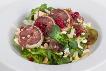 venison salad, watercress, hazelnuts, arugula on a plate close