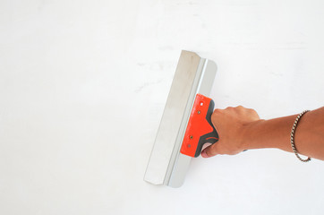 Hand holds trowel have plastered walls, completing the process.