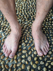 Textured cement  paved with stones and Foot Massage