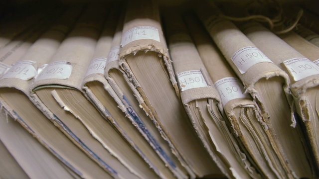 Old historical books on display in library pan shot from left to right
