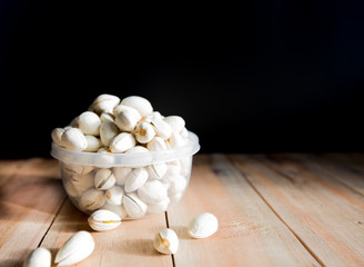 Pistachio put in bowl and some on wood floor 