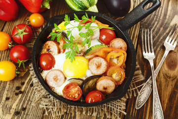 Fried eggs with vegetables and sausage