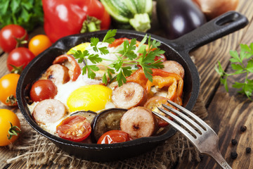 Fried eggs with vegetables and sausage