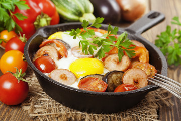 Fried eggs with vegetables and sausage