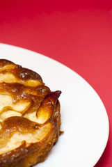 Apple pie on a white plate with red background