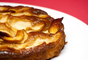 Apple pie on a white plate with red background