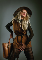 Fashion girl with bag posing in the studio.