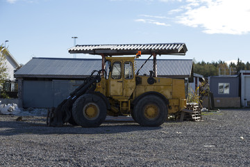A parked tractor in front of some sheds