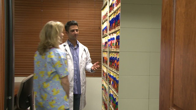 Nurse helps doctor find medical chart