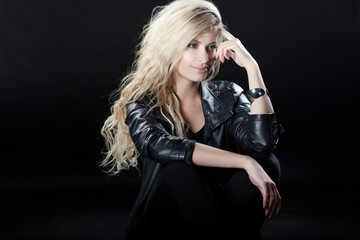 Fototapeta na wymiar Beautiful and stylish young blonde girl, black background