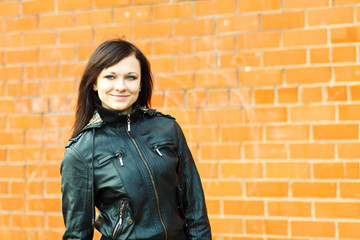 Brunette girl posing at brick wall.