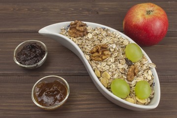 Healthy Diet breakfast of oatmeal, cereal and fruit. Foods full of energy for athletes. The concept of diet food. Preparing homemade breakfast. Vegetarian diet. Food on a wooden table.
