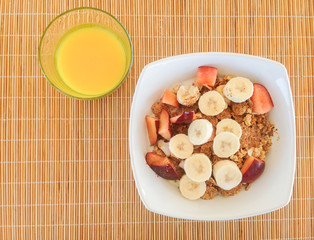 Healthy Breakfast of cereal and orange juice from above on a wicker place mat.