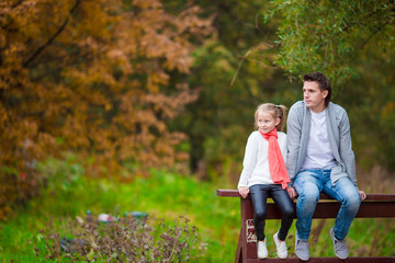 Adorable little girl with father in beautiful autumn park