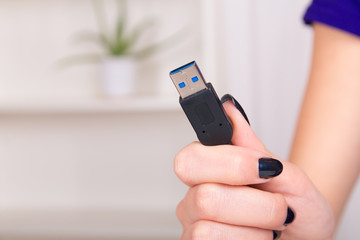 Girls hand holding computer cable