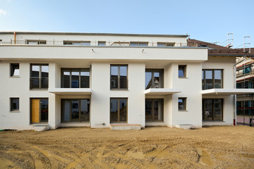 Baustelle vor Fertigstellung: Neubau Fassade von modernen Wohnhäusern