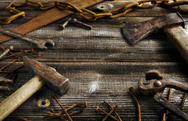 Rusty tools on old dark plank