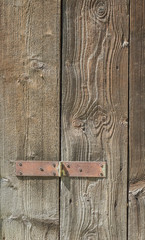 Close up of old wooden door with hinge