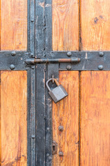 Wooden warehouse door secured with a latch and padlock