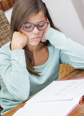 beautiful girl student doing her homework without motivation