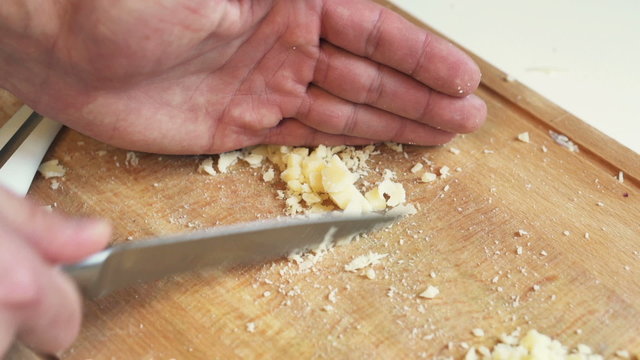 Man slicing cheese on table in kitchen
